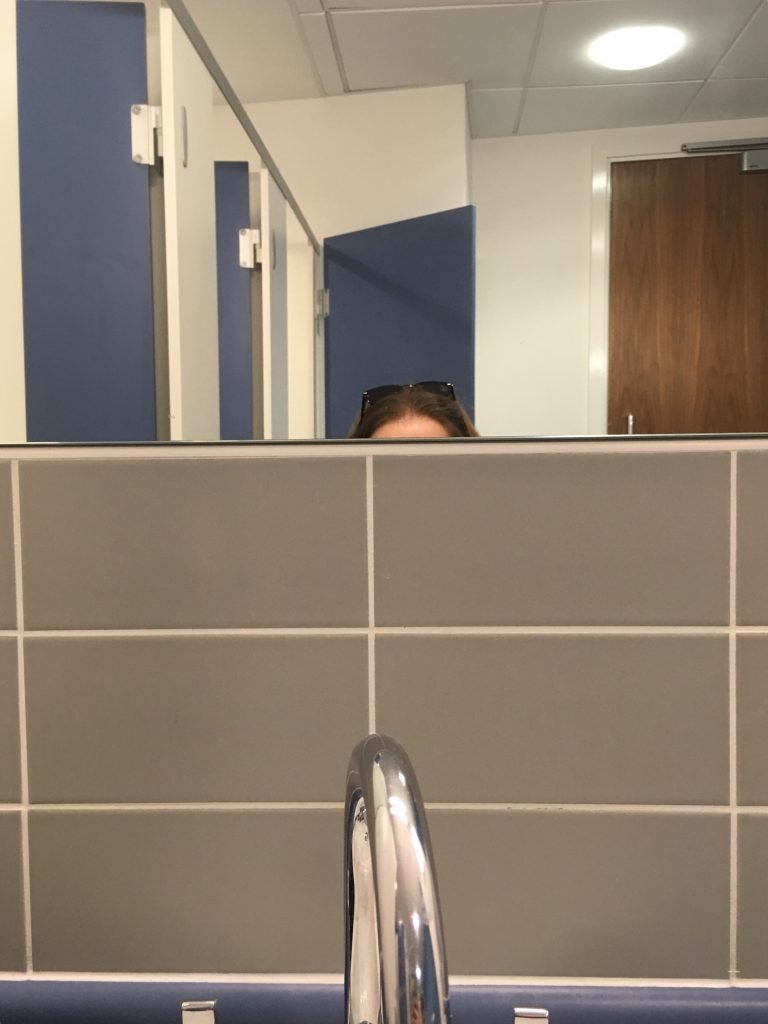 Hello Little Lady - standing at a sink in the toliets unable to see in the mirror because it's too high.